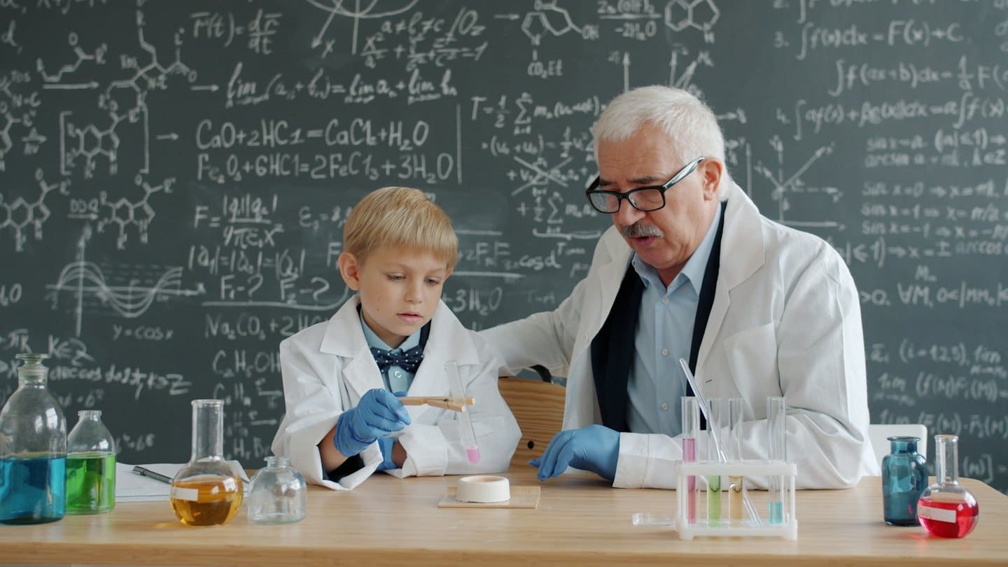 Man and boy conduct science experiment with test tubes.